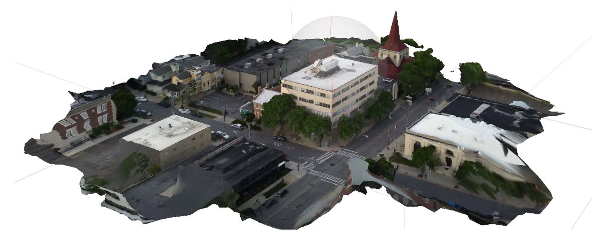 A 3D aerial view of a small urban area with buildings, including a church with a tall steeple, surrounded by roads and greenery.