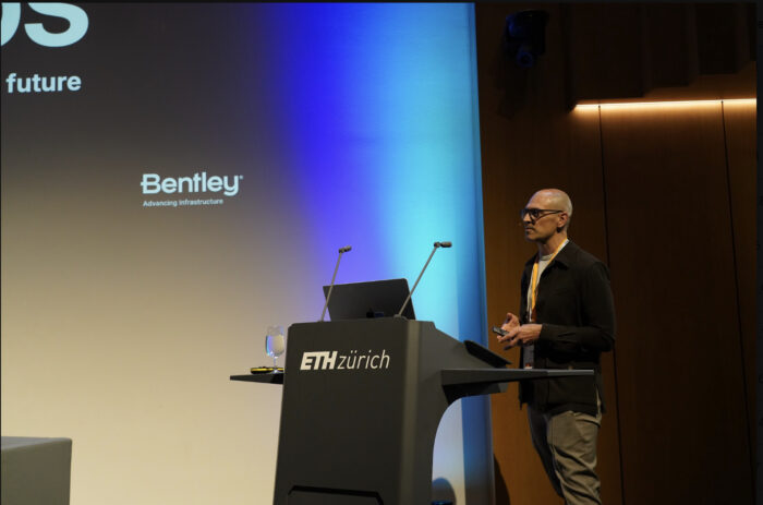 A person stands at a podium labeled ETH Z&uuml;rich, speaking in front of a presentation screen displaying the Bentley logo.