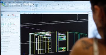 A person explores a 3D architectural model on a computer screen using Bentley PLANSTUDIO software, featured in the Partner Spotlight with Archway Systems.