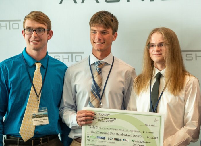 A Bentley Systems patrocina o concurso <em>Student Bridge</em>, no AASHTO Spring Meeting 3 alunos sorrindo e segurando um grande cheque