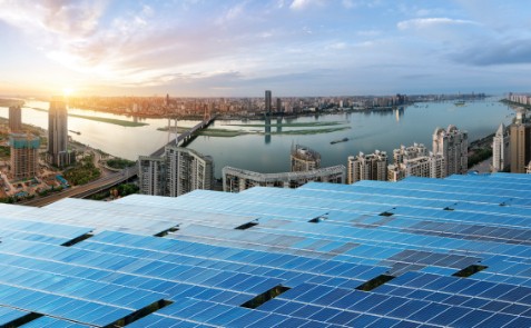 Pannelli solari che si affacciano su una città e un fiume