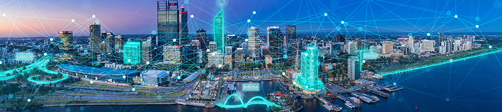 Panoramic aerial view of a modern cityscape at dusk with illuminated buildings and interconnected digital network overlays, highlighted during the 2024 ProjectWise Virtual User Conference.