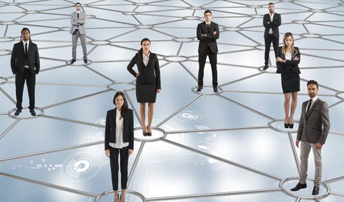 A group of business people standing on a network discussing.