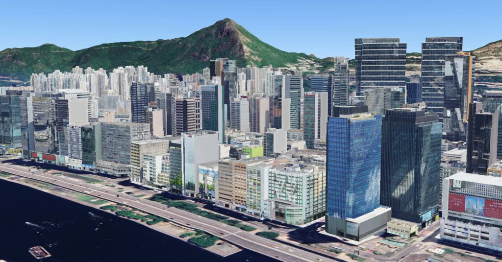 A high-angle view of cities featuring tall modern buildings, a waterfront road, and a green mountain in the background highlights smarter infrastructure seamlessly integrated with nature.