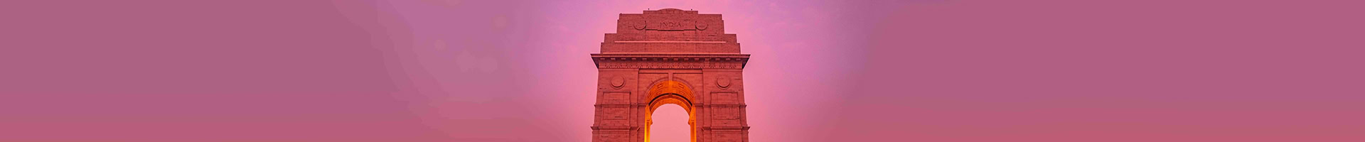 A prominent stone arch structure with intricate carvings, illuminated against a gradient pink and purple sky, evoking the vibrant spirit of India. Thank you for taking a moment to appreciate its beauty.