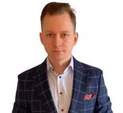 A person with short hair is wearing a checkered blazer over a light-colored shirt, standing against a plain white background, suitable for any professional profile related to SEO or Mining Projects.