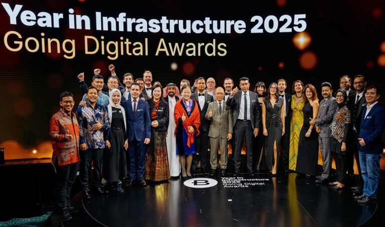 A group of people in formal attire pose on stage under a sign reading "Year in Infrastructure 2025 Going Digital Awards," celebrating their achievements at the prestigious Bentley Systems event A group of people in formal attire pose on stage under a sign reading "Year in Infrastructure 2025 Going Digital Awards," celebrating their achievements at the prestigious Bentley Systems event.