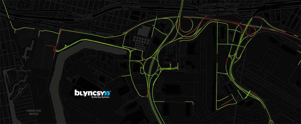 A dark map with highlighted roads in green and red displays traffic or movement data, reflecting the AI inflection point in infrastructure engineering; the "blyncsy by Bentley Systems" logo appears at the bottom right.