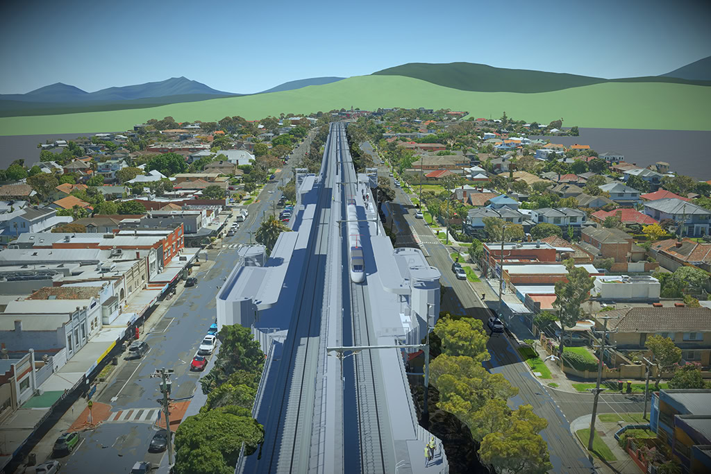 Aerial view of a suburban neighborhood featuring a new elevated train line and station, showcasing impressive bridge and tunnel engineering at the heart of the image.