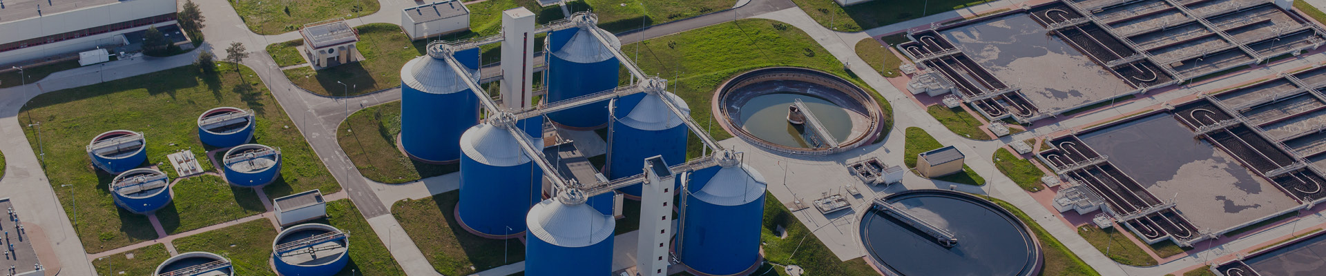 Aerial view of a water treatment plant with circular tanks, showcasing its design.