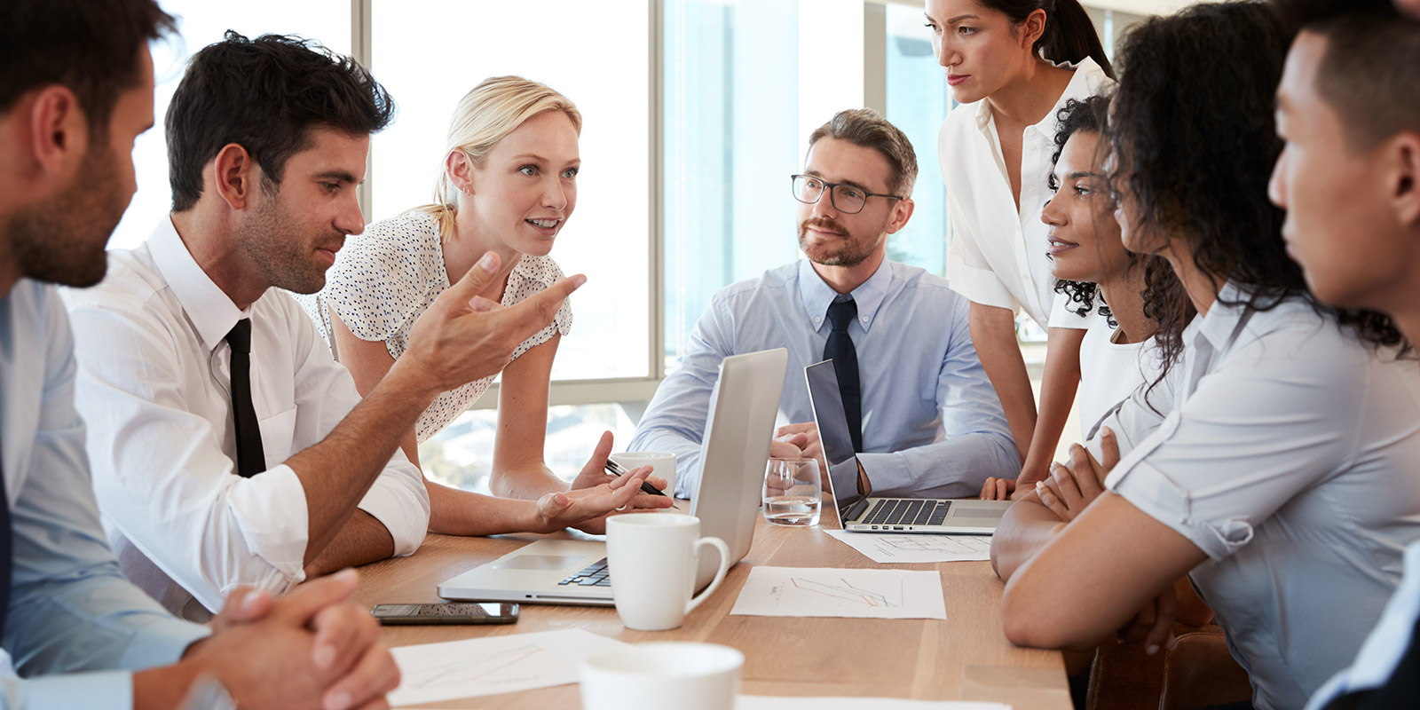 Grupo de empresários reunidos em torno de uma mesa no escritório