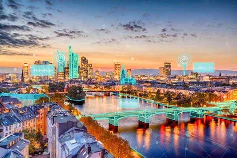 A cityscape at dusk with highlighted digital enhancements on buildings and bridges, designed using MicroStation, illustrating a smart city concept with vibrant, interconnected technology.