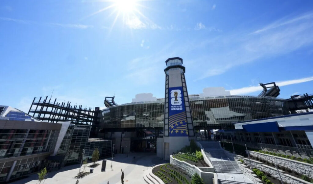 A sunny view of a modern stadium exterior in Dallas with a large FIFA World Cup 2026 banner displayed on the central tower, showcasing it as one of the impressive FIFA World Cup Stadiums.