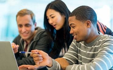 Three young individuals staring at a computer