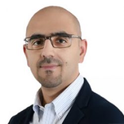 A man with glasses, a trimmed beard, and short hair, wearing a dark blazer and collared shirt, poses against a white background—exuding the confidence of an expert in Deep Foundation Analysis.