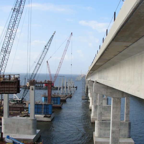 Construcción en curso en un puente de concreto sobre una masa de agua
