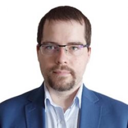 A man with short brown hair, glasses, and a trimmed beard wears a blue suit jacket and light blue shirt, facing forward against a white background—ideal for professionals in Deep Foundation Design or PLAXIS 3D projects.