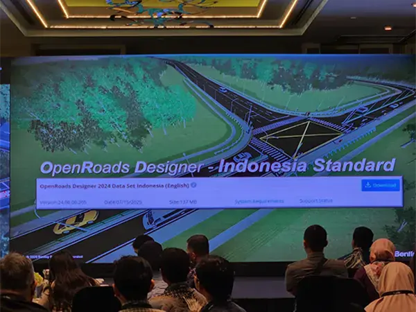 People attend a presentation in a conference room with a large screen displaying "OpenRoads Designer - Indonesia Standard" and a road design graphic.
