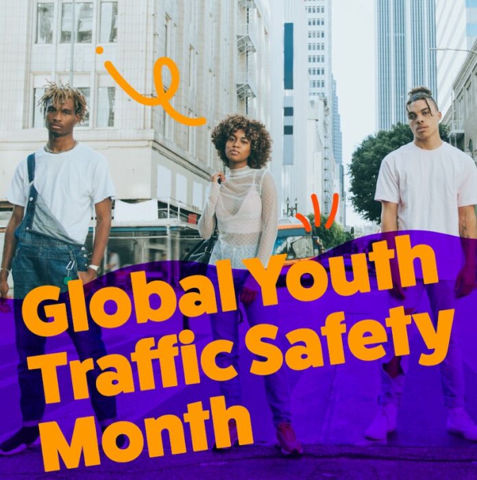 três adolescentes parados no meio de uma rua da cidade com um texto sobreposto em laranja que diz Mês Global pela Segurança da Juventude no Trânsito
