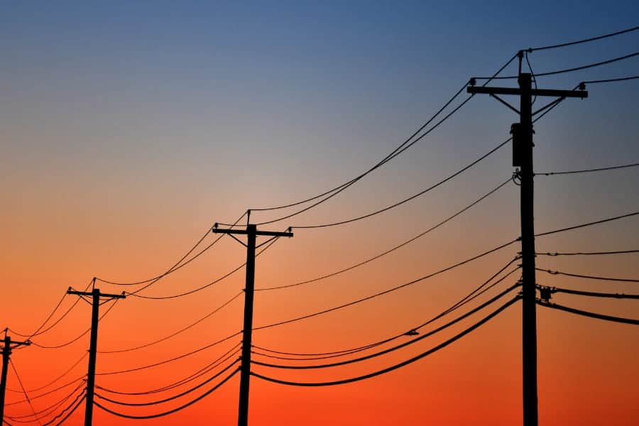 Utility poles and power lines at sunset
