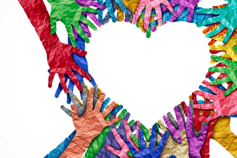 Mains en papier colorées formant un cœur