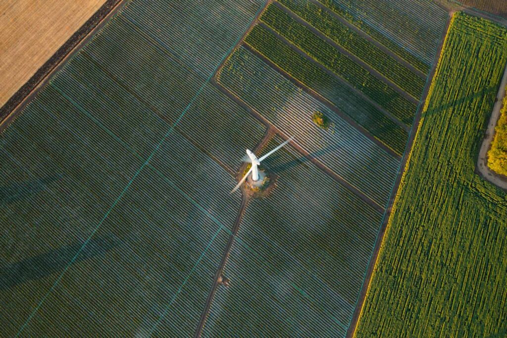 An aerial view of a windmill in a field.