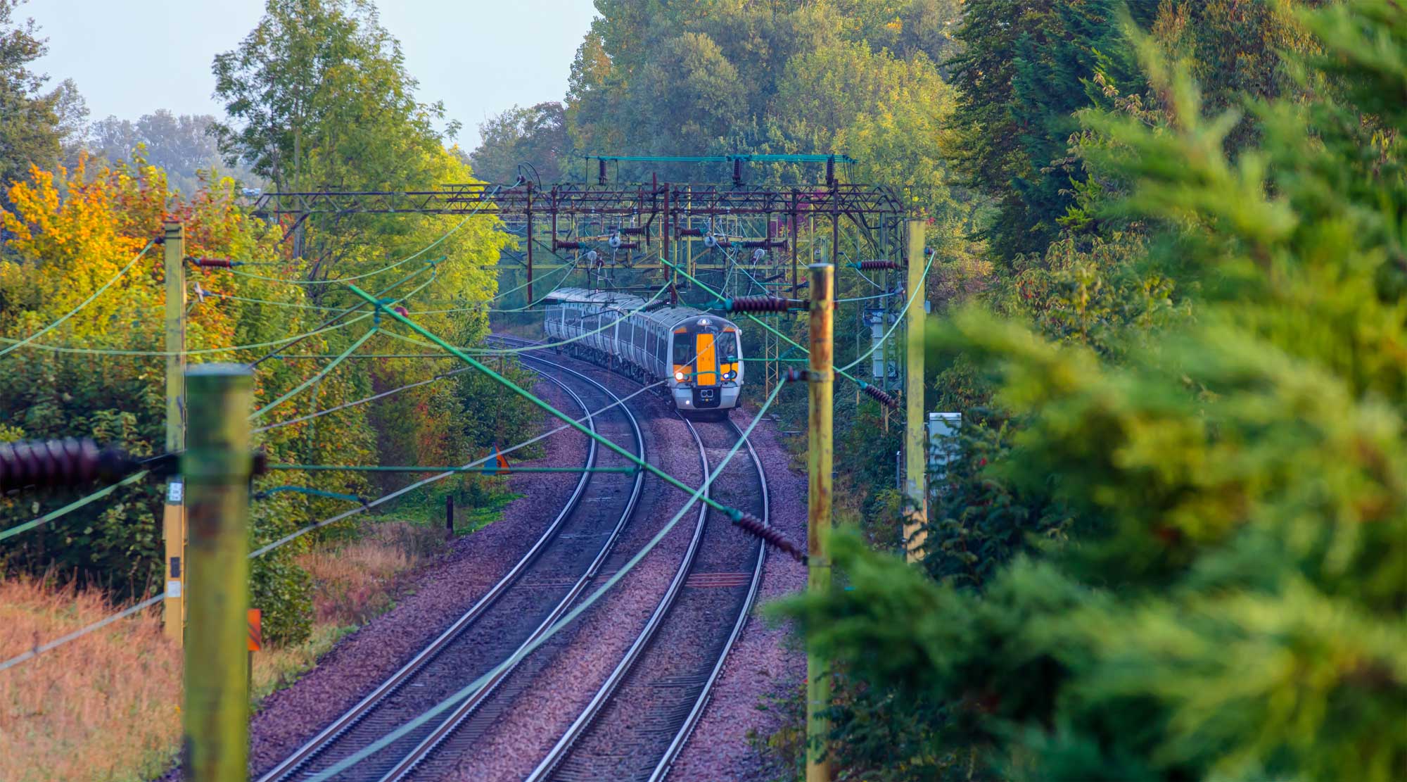 commuter train in motion in London going through the country side during fall