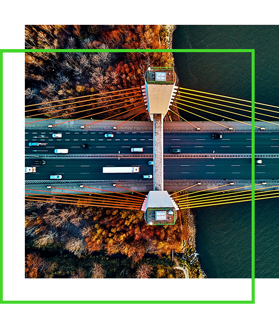 una vista aérea de un puente que va a un río con una frontera verde superpuesta