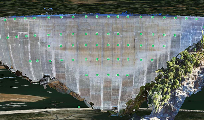 A view of New Bullards Bar Dam with a lot of green dots on it.