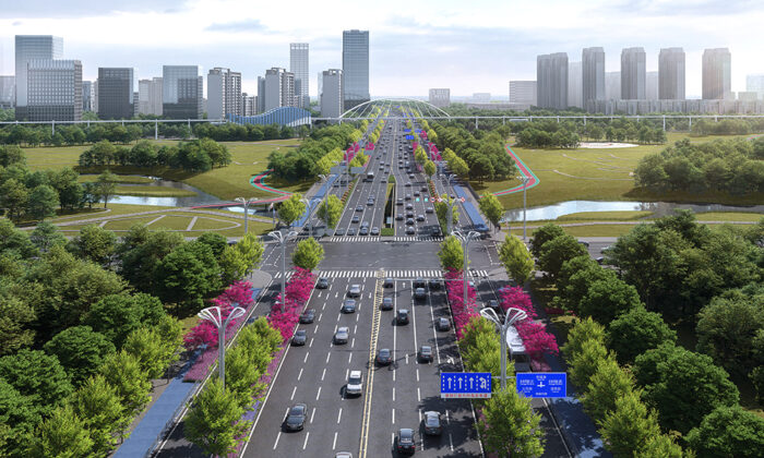 A multi-lane highway with numerous cars passes through a landscaped urban area with trees and pink flowers, flanked by modern buildings and green spaces.
