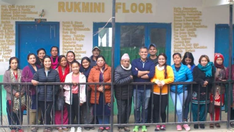 A group of people standing together in front of Rukmini Floor