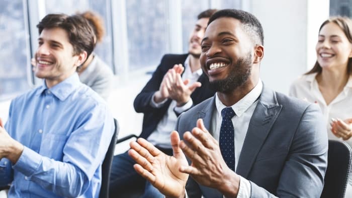 Persone che sorridono e applaudono durante una riunione