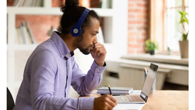 man working at computer with headphones