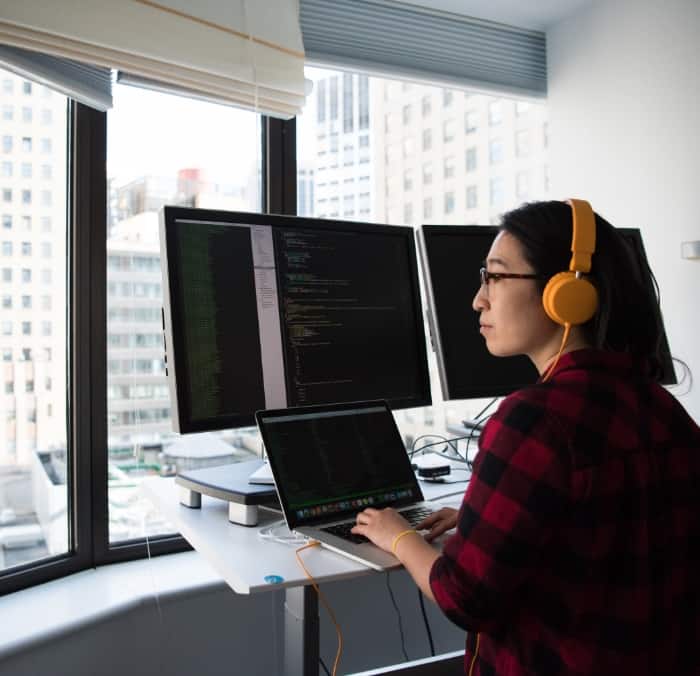 woman working on multiple screens