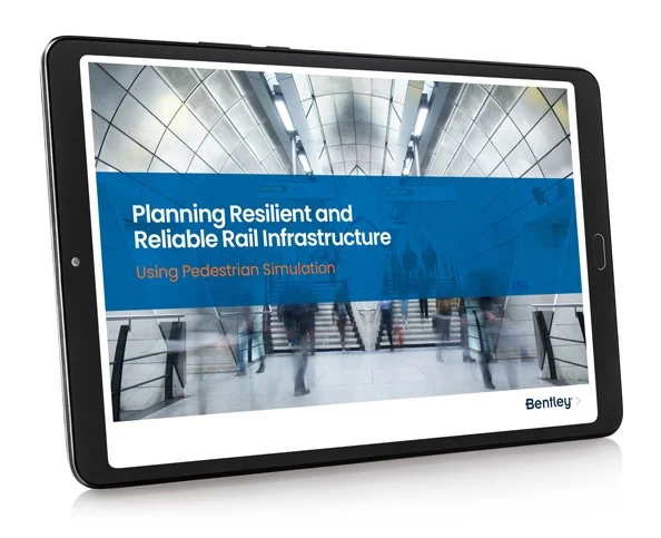 A tablet displaying a presentation slide about "planning resilient and reliable rail infrastructure" with a background image of a busy train station.