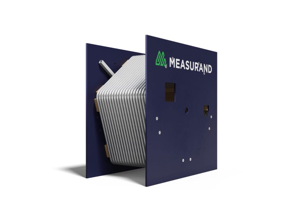 A blue metal enclosure labeled "Measurand" houses a large, coiled sensor cable with connectors partially visible.