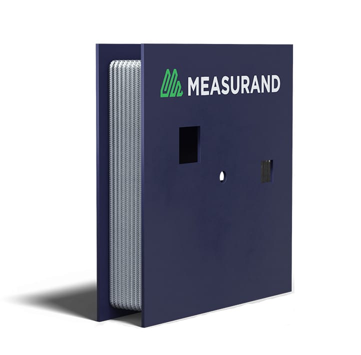 A blue rectangular device labeled "MEASURAND" with a coiled cable visible on one side and several square and circular cutouts on the front panel.