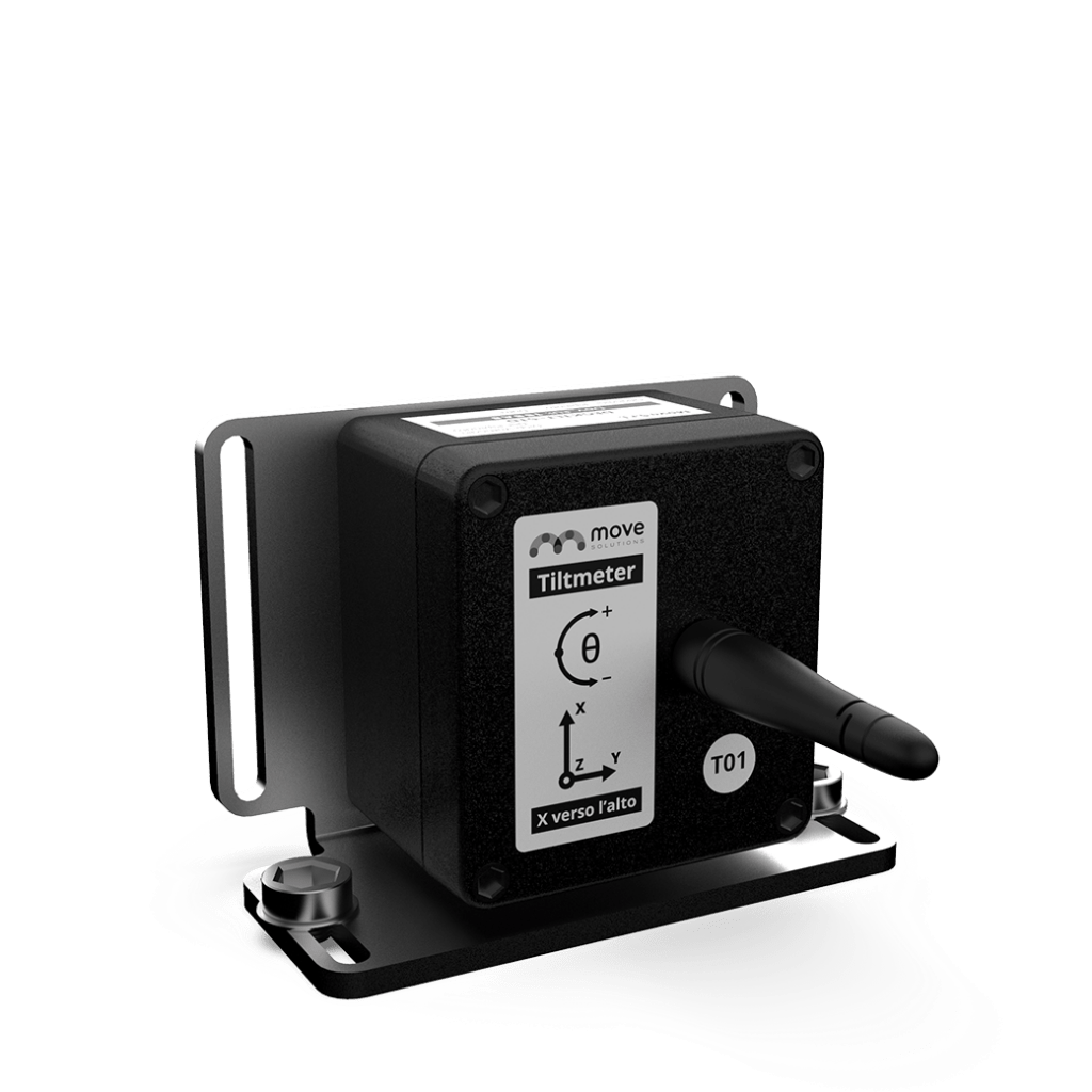 Black tiltmeter device with a label showing measurement axes, mounted on a metal bracket with two screws and a protruding connector.