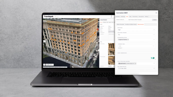 A laptop displays a 3D building model with highlighted areas on screen, alongside a Trenspek pop-up window showing details about a corrosion issue.