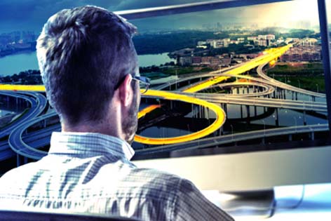 A man with glasses views a large screen displaying an intricate highway interchange, showcasing excellence in infrastructure design.