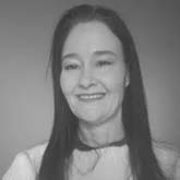 Black and white photo of a woman with long dark hair, smiling. She is wearing a light-colored top. The background is plain, focused solely on her as if she’s offering her expertise for various projects in the field of MicroStation.