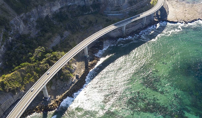 aerial view of road and bridge around shore line