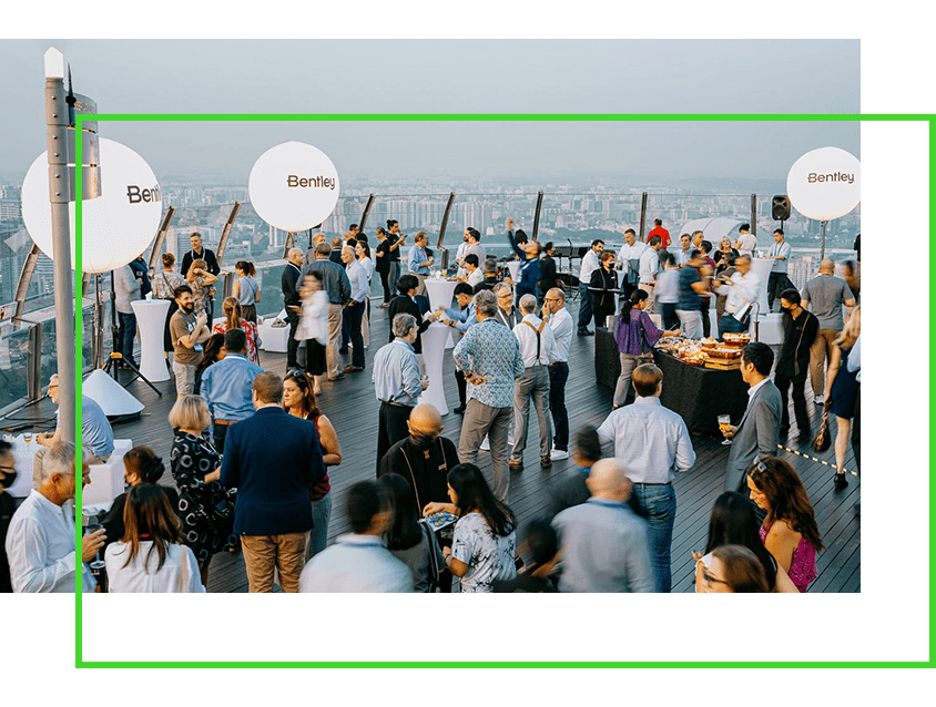 Outdoor corporate event with attendees networking on a rooftop.