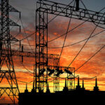 líneas eléctricas y estación eléctrica a contraluz de una puesta de sol