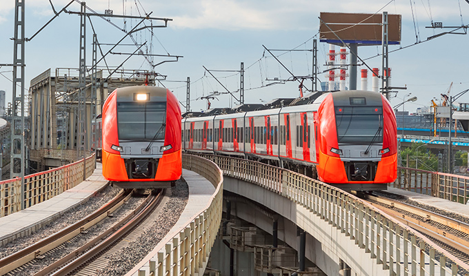 czerwone pociągi metra zbliżające się do widza, jadące po torach kolejowych
