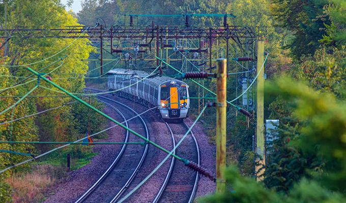 Pociąg podmiejski w ruchu w Londynie jadący przez wieś jesienią