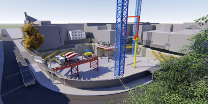 The construction site, part of the South Eastern Program Alliance, showcases cranes and a cement mixer amidst the unfinished building structure. Trees and fencing surround the area, setting the stage for future user stories to unfold.