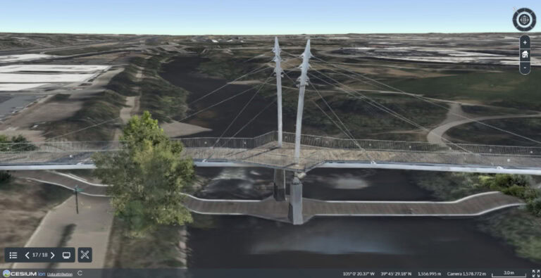 A cable-stayed pedestrian bridge spans over a river, surrounded by trees and pathways, viewed from an elevated digital map perspective—a stunning example of infrastructure engineering enhanced by reality modeling A cable-stayed pedestrian bridge spans over a river, surrounded by trees and pathways, viewed from an elevated digital map perspective—a stunning example of infrastructure engineering enhanced by reality modeling.
