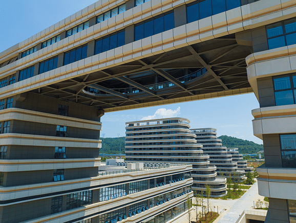 An eye-level view of a modern office complex connected by an elevated sky-bridge, highlighting innovative architectural engineering, collaborative spaces, and sustainable commercial design.